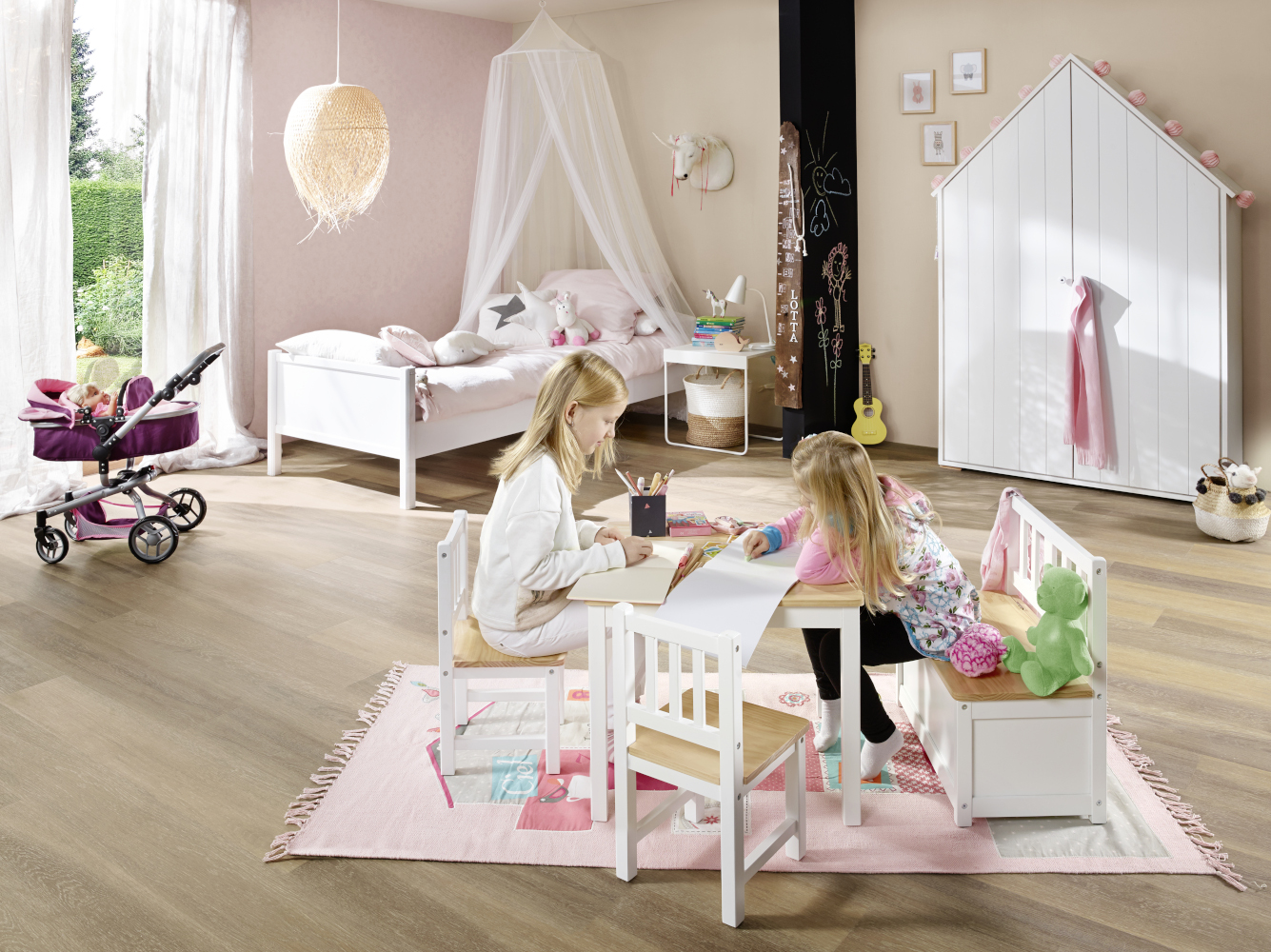 Zwei Kinder beim Malen an der BOMI Kindersitzgruppe im Kinderzimmer